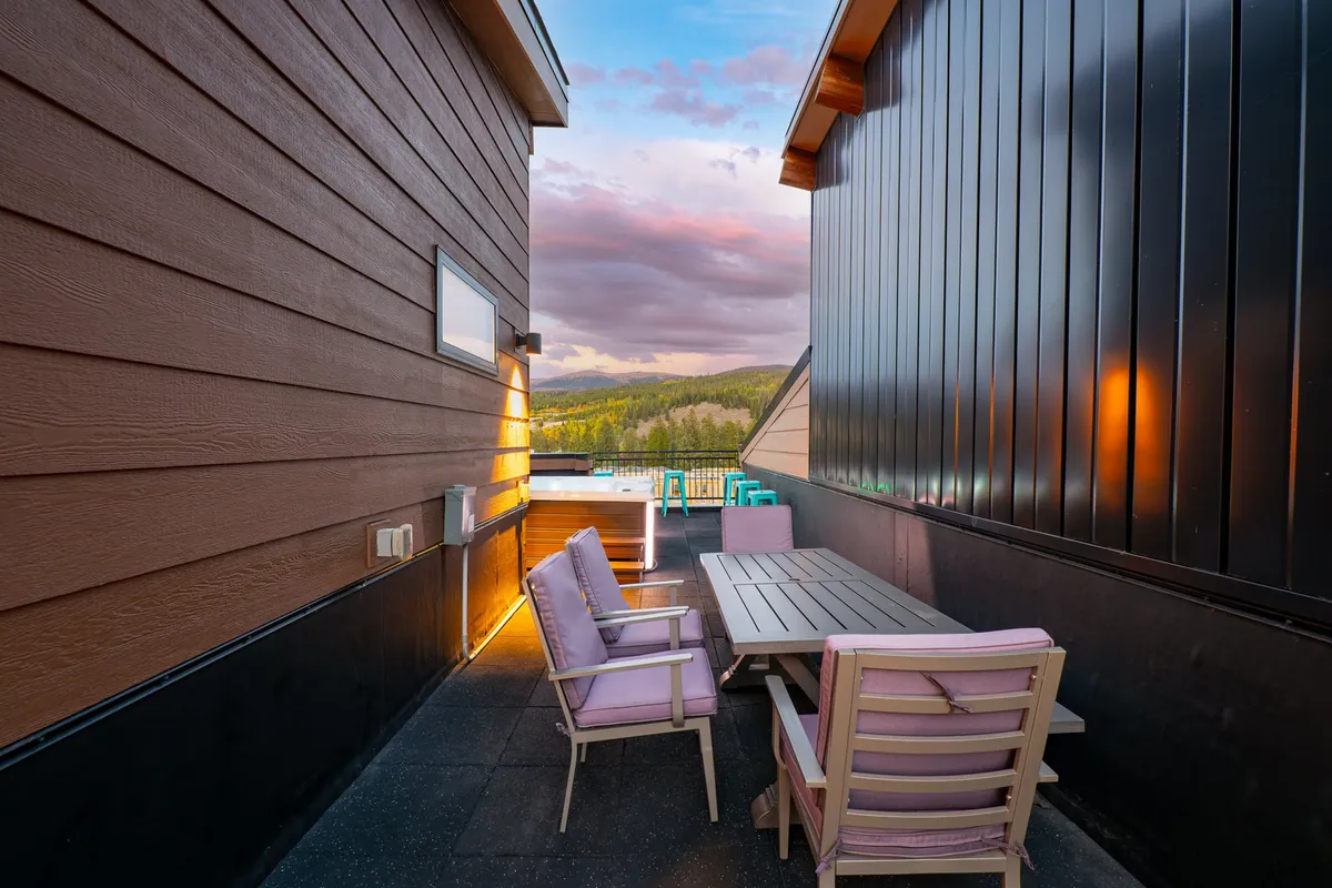 An inviting outdoor seating area with a table set against a backdrop of mountain views. The space is ideal for dining, relaxing, or socializing while enjoying the scenic natural surroundings.